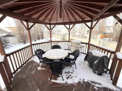 Snow covered deck with a grill and outdoor dining space - 