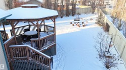 Snow covered deck with a gazebo, a fenced backyard, and stairway - 