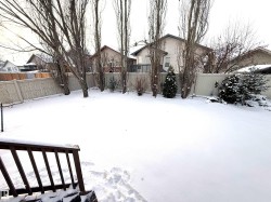 Yard covered in snow with a fenced backyard - 