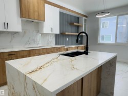 Kitchen with white cabinetry, light marble finish floors, open shelves, and light stone counters - 