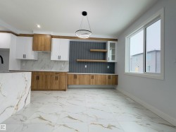 Kitchen featuring brown cabinets, white cabinetry, light marble finish floors, open shelves, and backsplash - 