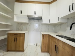 Kitchen featuring light marble finish flooring, tasteful backsplash, and brown cabinetry - 