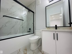 Full bathroom with vanity, combined bath / shower with glass door, and light marble finish flooring - 