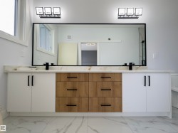 Bathroom featuring light marble finish floors and double vanity - 