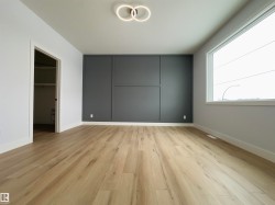 Unfurnished bedroom featuring a spacious closet and light wood-style flooring - 