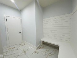 Mudroom featuring light marble finish flooring and baseboards - 