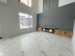 Unfurnished living room featuring light marble finish flooring, a high ceiling, and wooden walls - 