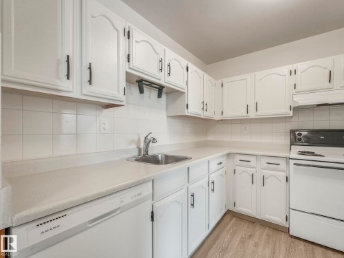 Kitchen with white appliances, light countertops, and white cabinetry - 406 10125 109 Street, Edmonton, AB - Indoor Photo Showing Kitchen