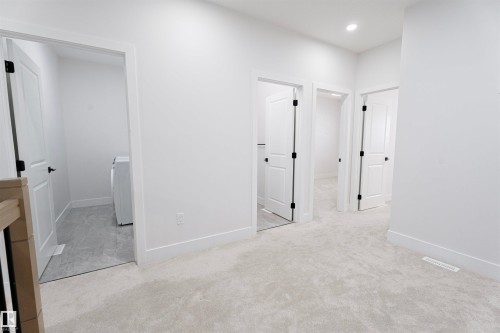 Unfurnished bedroom with light colored carpet, washer / clothes dryer, and recessed lighting - 244 Rolston Wynd, Leduc, AB - Indoor Photo Showing Other Room