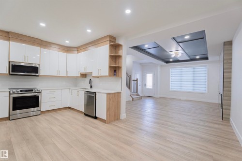 Kitchen with open shelves, light countertops, appliances with stainless steel finishes, white cabinets, and open floor plan - 244 Rolston Wynd, Leduc, AB - Indoor Photo Showing Kitchen