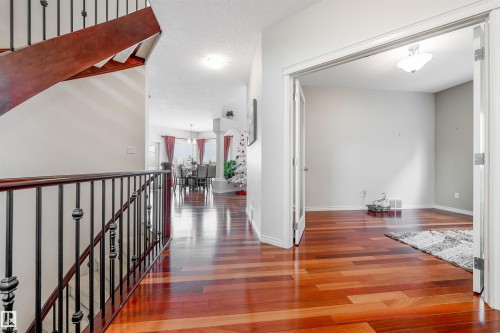 Hallway featuring a textured ceiling, wood finished floors, and an upstairs landing - 20524 58 Avenue, Edmonton, AB - Indoor Photo Showing Other Room
