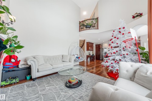 Living area featuring stairway, wood finished floors, and a towering ceiling - 20524 58 Avenue, Edmonton, AB - Indoor Photo Showing Living Room