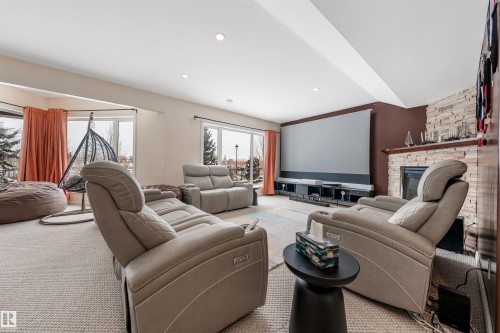 Cinema featuring a stone fireplace, recessed lighting, and carpet flooring - 20524 58 Avenue, Edmonton, AB - Indoor Photo Showing Living Room With Fireplace
