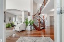 Entryway with light wood-style flooring, a towering ceiling, arched walkways, stairs, and a chandelier - 20524 58 Avenue, Edmonton, AB  - Indoor Photo Showing Other Room 