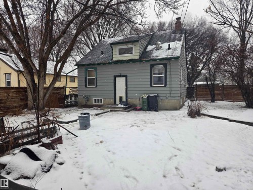 Snow covered house featuring a fenced backyard, a patio, and a chimney - 11516 88 Street, Edmonton, AB - Outdoor