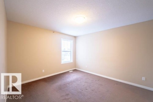Carpeted empty room with a textured ceiling and baseboards - 3117 Arthurs Crescent, Edmonton, AB - Indoor Photo Showing Other Room