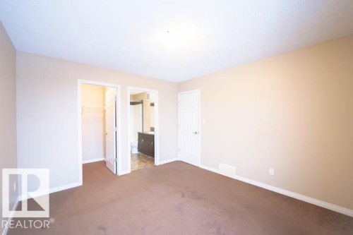Unfurnished bedroom with a walk in closet, dark colored carpet, and ensuite bath - 3117 Arthurs Crescent, Edmonton, AB - Indoor Photo Showing Other Room