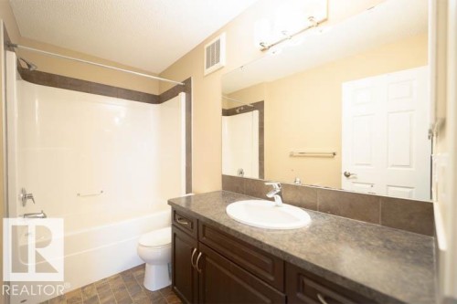 Bathroom featuring bathing tub / shower combination, vanity, and a textured ceiling - 3117 Arthurs Crescent, Edmonton, AB - Indoor Photo Showing Bathroom