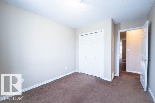 Unfurnished bedroom featuring dark carpet, a closet, and a textured ceiling - 3117 Arthurs Crescent, Edmonton, AB - Indoor