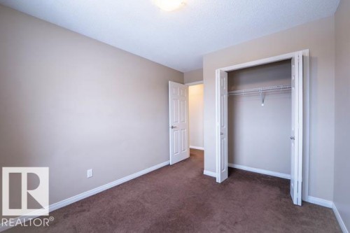 Unfurnished bedroom featuring dark colored carpet and a closet - 3117 Arthurs Crescent, Edmonton, AB - Indoor