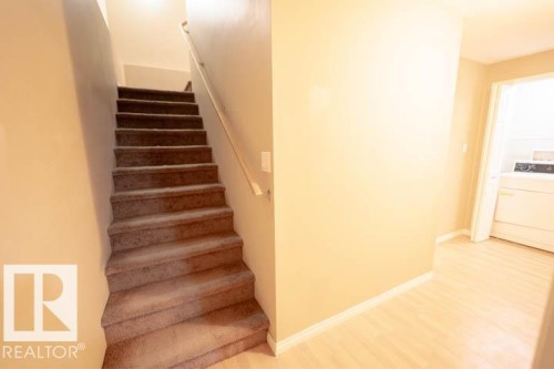Staircase featuring washer / clothes dryer and wood finished floors - 3117 Arthurs Crescent, Edmonton, AB - Indoor Photo Showing Other Room