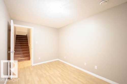 Empty room with stairs and light wood-style flooring - 3117 Arthurs Crescent, Edmonton, AB - Indoor Photo Showing Other Room