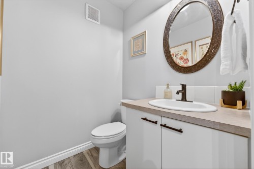 Half bath featuring vanity and light wood-style floors - 7 Grandview Ridge, St. Albert, AB - Indoor Photo Showing Bathroom