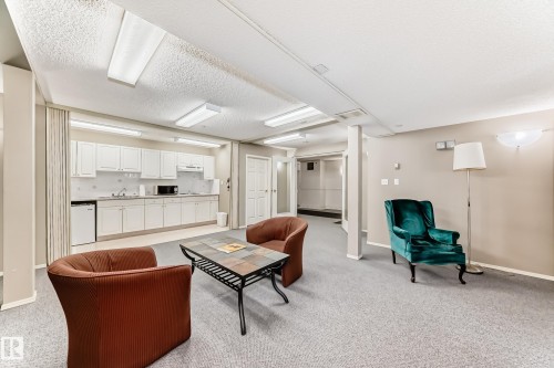 Living area featuring light colored carpet and a textured ceiling - 507 11716 100 Avenue, Edmonton, AB - Indoor