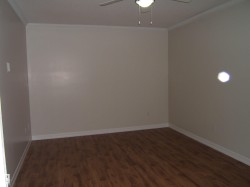 Unfurnished room featuring ornamental molding, dark wood finished floors, and a ceiling fan - 