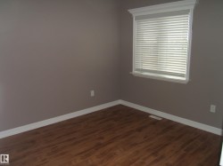 Unfurnished room featuring baseboards and dark wood-type flooring - 