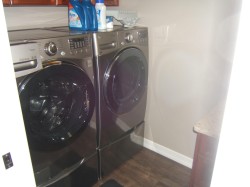 Washroom featuring cabinet space, dark wood finished floors, and washing machine and clothes dryer - 