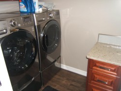 Washroom with dark wood-style flooring and independent washer and dryer - 