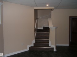Stairway featuring a paneled ceiling and baseboards - 