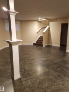 Finished basement with a paneled ceiling and stairway - 