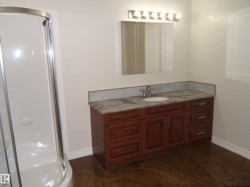 Bathroom featuring a shower stall and vanity - 