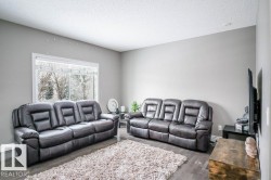 Living room with a textured ceiling and dark wood-type flooring - 