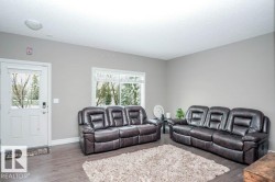 Living room featuring dark wood-type flooring and a textured ceiling - 