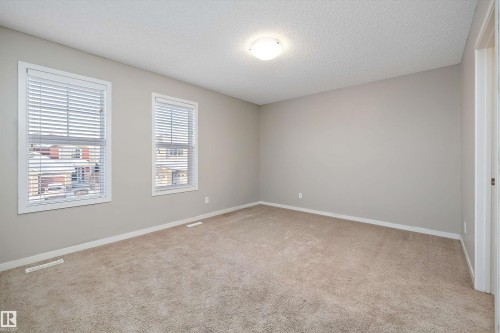 Unfurnished room with a textured ceiling and light colored carpet - 5247 20 Avenue Sw, Edmonton, AB - Indoor Photo Showing Other Room