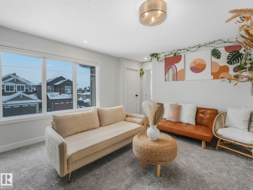 Living area featuring carpet flooring and a textured ceiling - 4447 Kinsella Green, Edmonton, AB - Indoor Photo Showing Living Room
