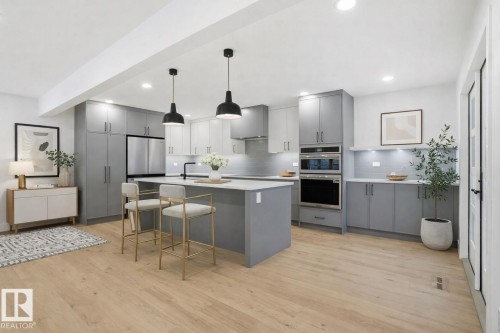 Kitchen featuring gray cabinetry, a breakfast bar, hanging light fixtures, stainless steel double oven, and recessed lighting - 14604 Mackenzie Drive, Edmonton, AB - Indoor Photo Showing Kitchen With Upgraded Kitchen