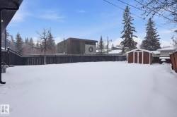 Yard layered in snow with a fenced backyard and a shed - 