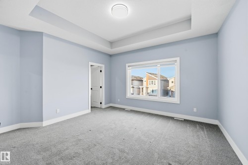 Carpeted spare room with a tray ceiling - 829 Morris Avenue, Leduc, AB - Indoor