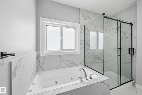 Full bathroom with marble finish floors, a whirlpool tub, and a marble finish shower - 829 Morris Avenue, Leduc, AB - Indoor Photo Showing Bathroom