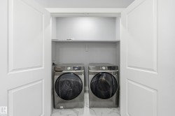 Washroom with marble look tiles and separate washer and dryer - 