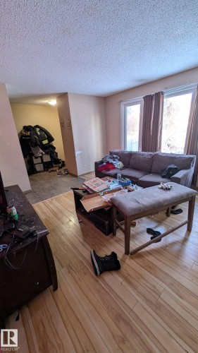 Living area with light wood-type flooring and a textured ceiling - 4 Amberly Crest, Edmonton, AB - Indoor
