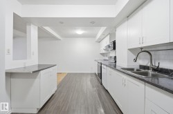 Kitchen featuring dark countertops, white cabinets, stainless steel electric range oven, and dark wood-type flooring - 