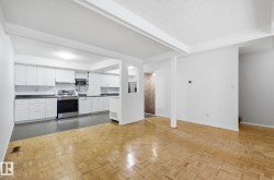Kitchen with white cabinetry, appliances with stainless steel finishes, dark countertops, a textured ceiling, and open floor plan - 