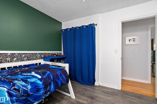 Bedroom with wood finished floors and a textured ceiling - 145 Plum Crescent, Wetaskiwin, AB - Indoor Photo Showing Bedroom