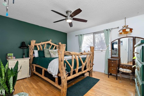 Bedroom featuring light wood-style flooring, a textured ceiling, and ceiling fan - 145 Plum Crescent, Wetaskiwin, AB - Indoor Photo Showing Bedroom