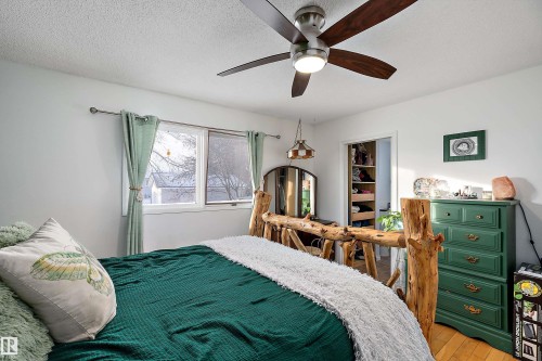 Bedroom featuring a textured ceiling, hardwood / wood-style flooring, and a ceiling fan - 145 Plum Crescent, Wetaskiwin, AB - Indoor Photo Showing Bedroom